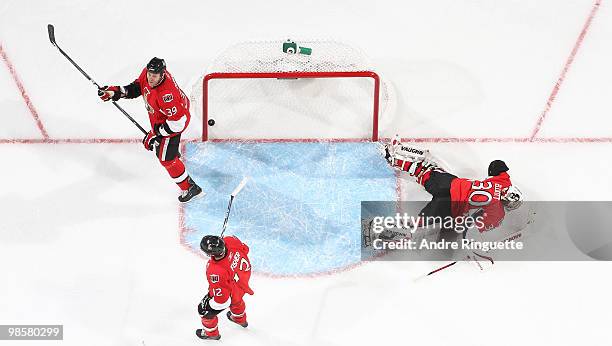 Matt Carkner, Brian Elliott and Mike Fisher of the Ottawa Senators react after a goal by the Pittsburgh Penguins in Game Four of the Eastern...