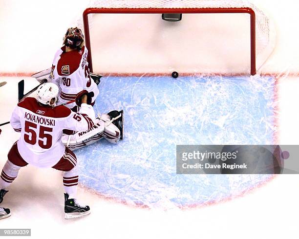 Ilya Bryzgalov of the Phoenix Coyotes and teammate Ed Jovanovski look back at the puck during Game Four of the Eastern Conference Quarterfinals of...