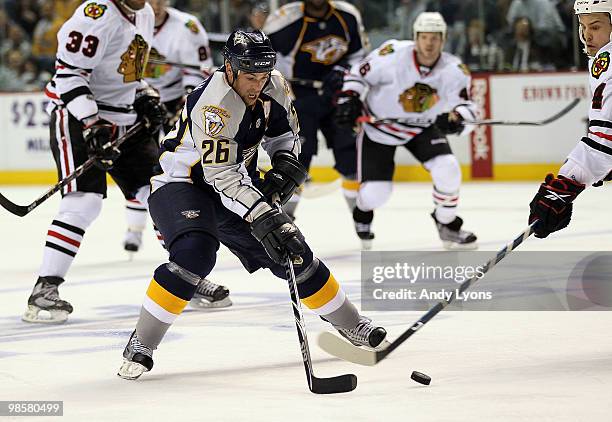 Steve Sullivan of the Nashville Predators and Niklas Hjalmarsson#4 of the Chicago Blackhawks battle for the puck during game 3 of the Western...