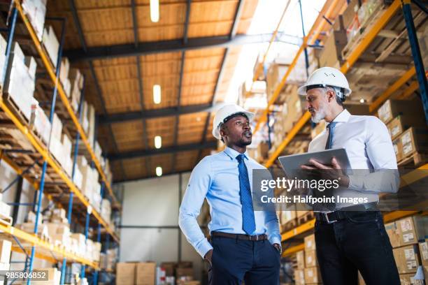 men managers with tablet in a warehouse. - distribution warehouse technology stock pictures, royalty-free photos & images