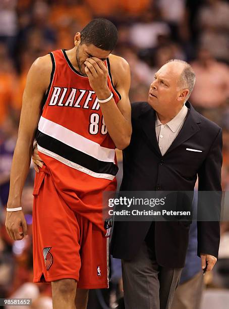 Nicolas Batum of the Portland Trail Blazers walks off the court with athletic trainer Jay Jensen after an injury during Game Two of the Western...