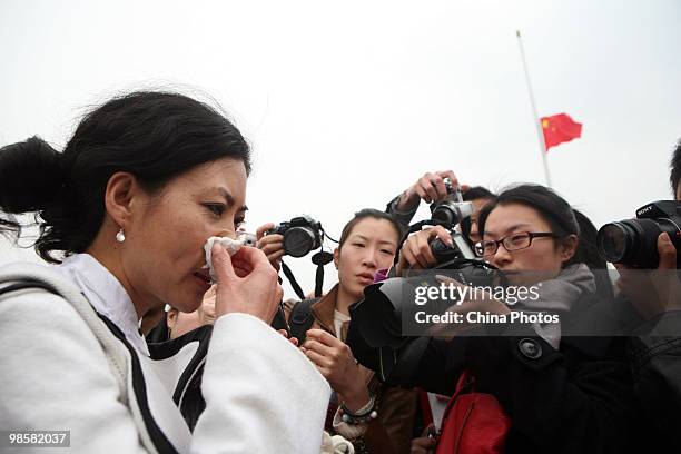 Medias surround a woman from Qinghai who came to mourn victims in the Yushu earthquake at the Tiananmen Square on April 21, 2010 in Beijing, China....