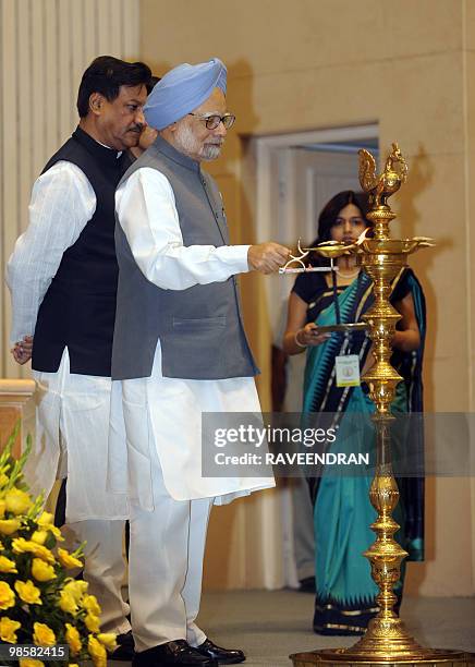 Indian Prime Minister Manmohan Singh lights an oil lamp at the inauguration of Indian Civil Services Day in New Delhi on April 21, 2010. Calling for...