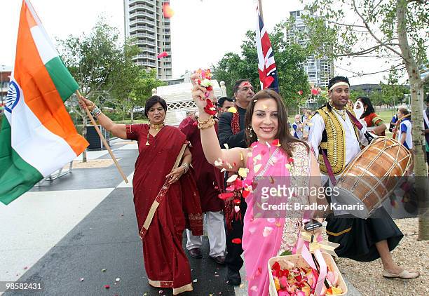 Traditional Indian dancers throw rose petals over Triathlon champion Emma Snowsill of Australia as she carries the Queens Baton as part of the Delhi...