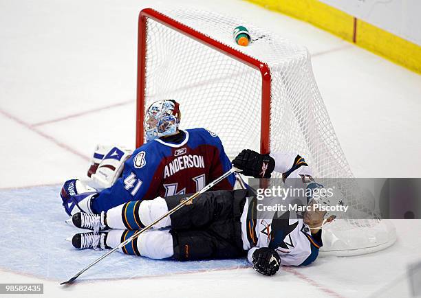 Goaltender Craig Anderson of the Colorado Avalanche gets taken down in the crease by Manny Malhotra of the San Jose Sharks in the third period of...