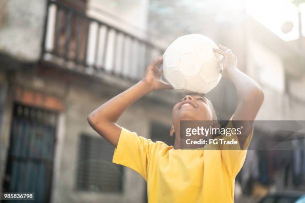 brasilianska barn spelar fotboll på gatan - brazilian playing football bildbanksfoton och bilder