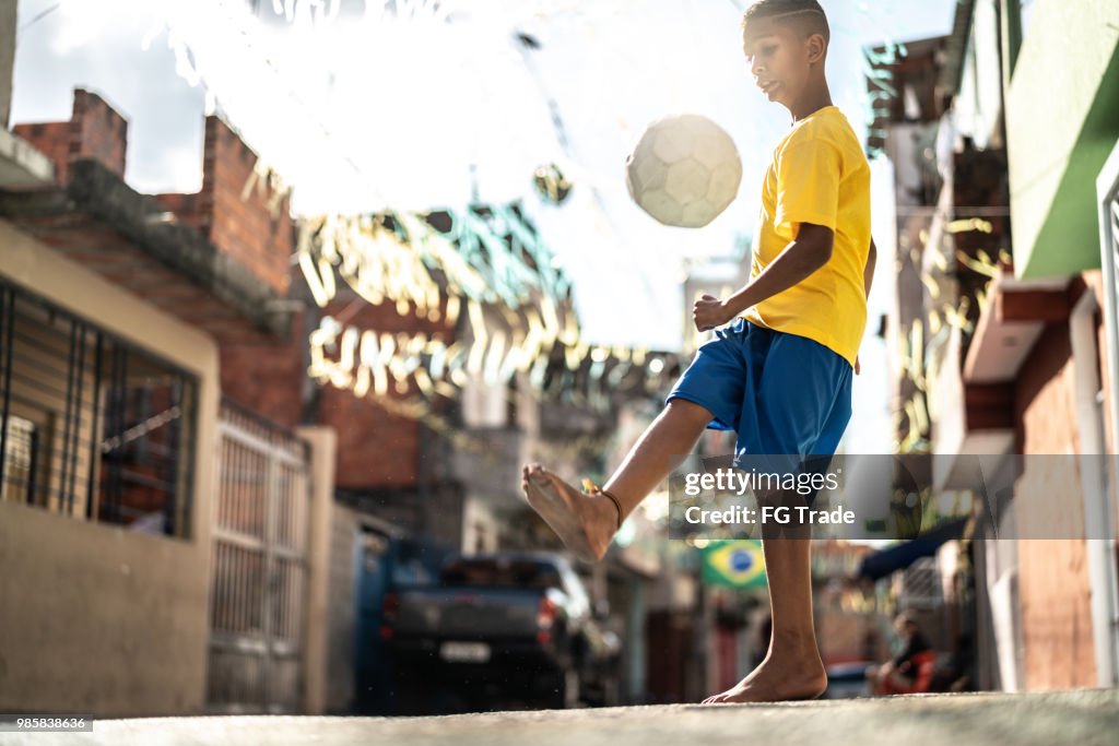 Brazilian Kid Playing Soccer in the Street