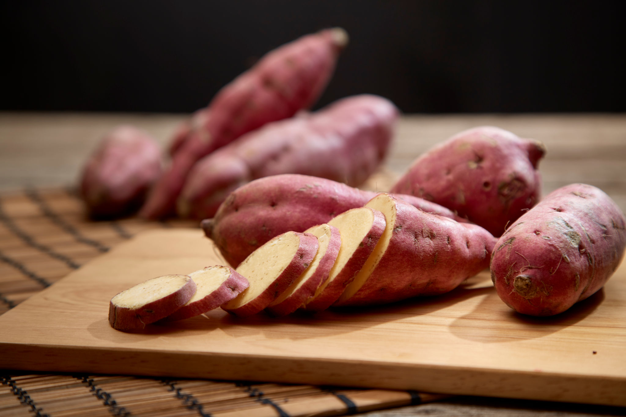 Raw sweet potato on wooden table Raw sweet potato on wooden table