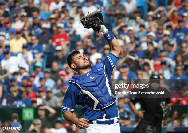 Luke Maile of the Toronto Blue Jays catches a foul pop up in the fifth inning during MLB game action against the Washington Nationals at Rogers...