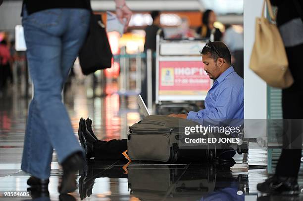 Man uses his laptop while waiting at Hong Kong's international airport on April 21, 2010. Thousands of frustrated passengers crowded Asia-Pacific...