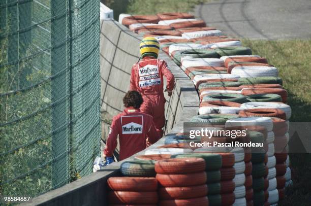 Ayrton Senna driving the Marlboro McLaren-Honda MP4/5 and Alain Prost in the Scuderia Ferrari 641 walk back to the pits after their crash at the...