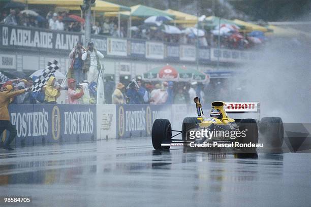 Thierry Boutsen from Belgium driving the Canon Williams Renault FW13 Renault V10 in the rain punches the air from the cockpit in celebration after...