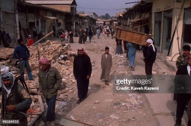 Iraqi people in the rubble after Allied bombers blasted a neighborhood in the center of Fallujah during the Gulf War, 19th February 1991.