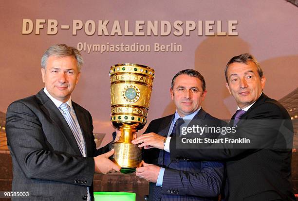 Wolfgang Niersbach, general seceratary of the DFB watches as Klaus Allofs, sports director of Werder Bremen hands over the cup to Klaus Wowereit,...