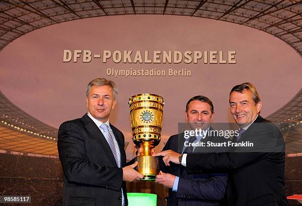 Wolfgang Niersbach, general seceratary of the DFB watches as Klaus Allofs, sports director of Werder Bremen hands over the cup to Klaus Wowereit,...
