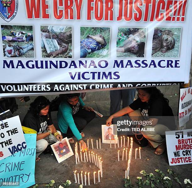 Relatives of the journalists killed in the infamous Maguindanao massacre display portraits of their bereaved loved ones next to lighted candles...