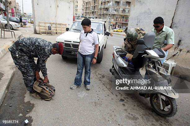 Iraqi security forces search Iraqis in a Baghdad street on April 21 as the government stepped up security to guard against any potential reprisals...