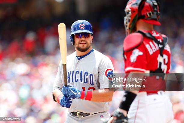 Kyle Schwarber of the Chicago Cubs talks with Tucker Barnhart of the Cincinnati Reds at home plate during the game at Great American Ball Park on...