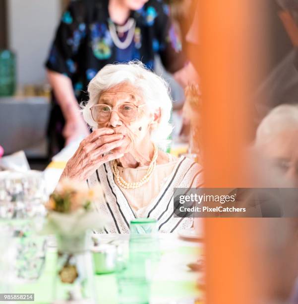 105 jahre alte senior dame genießt ihr mittagessen in einem altersheim am esstisch sitzen - 90 plus years stock-fotos und bilder