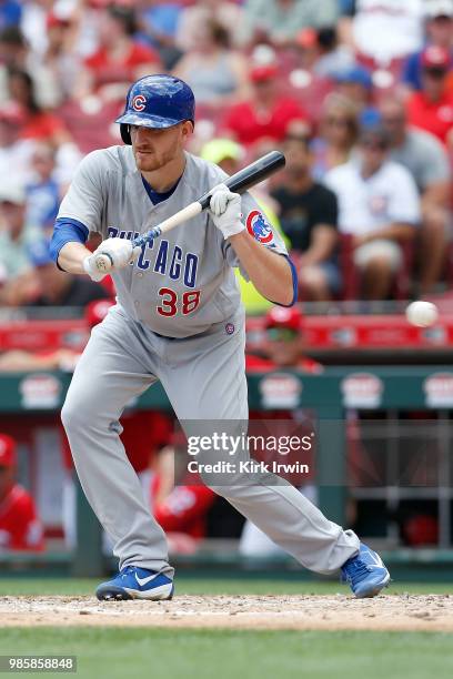 Mike Montgomery of the Chicago Cubs attempts to bunt the ball during the game against the Cincinnati Reds at Great American Ball Park on June 24,...
