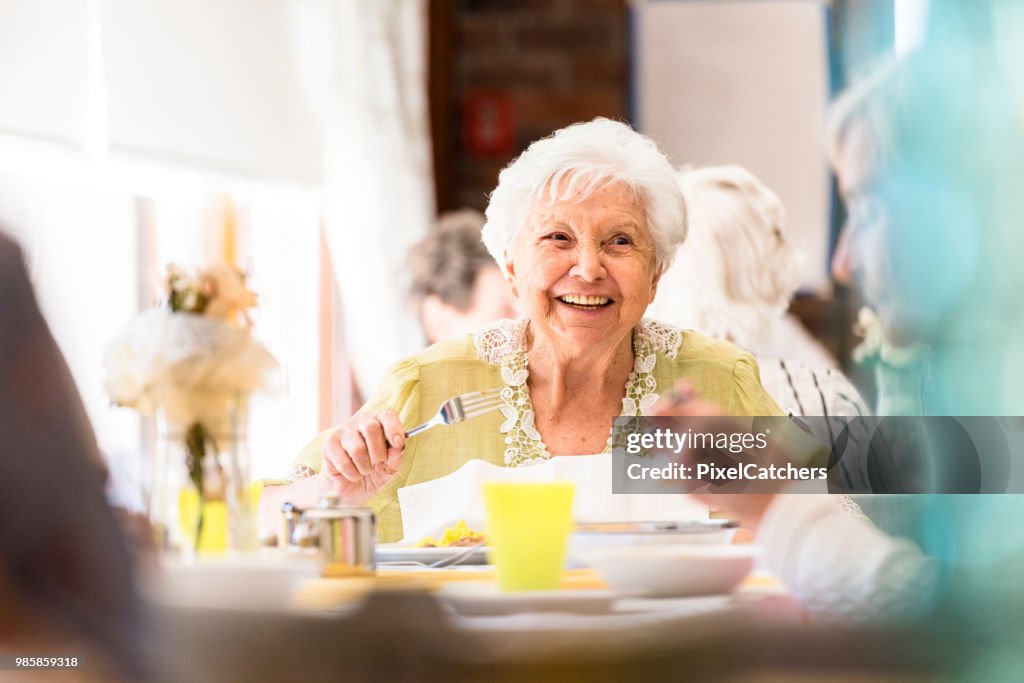 Porträt einer lächelnden senior Frau Mittagessen mit Freunden