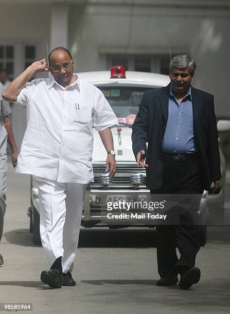 Indian Minister of Agriculture Sharad Pawar and Board of Control for Cricket in India chief Shashank Manohar walk following a meeting at Pawar's...