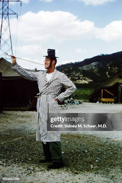 Portrait of Lieutenant John 'Mumsworthy' Holden, of the 8063rd MASH , as he poses in a striped robe and a gat , and holds a long pipe, South Korea,...