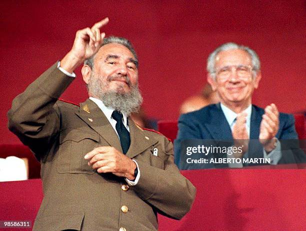 Cuban President Fidel Castro waves to the Cuban Olympic delegation as they pass the reviewing stand during the opening ceremony of the Summer...