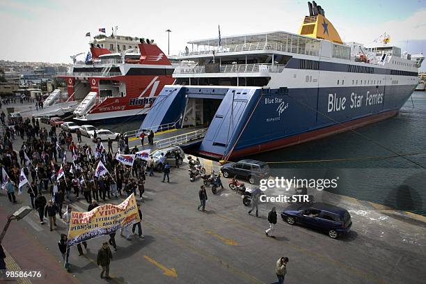Greek PAME union, representing Communist workers, march by ferries on April 21 after blocking their departure in the port of Piraeus during their...