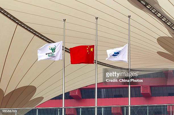 The flag of Shanghai 2010 World Expo and the Chinese national flag fly at half-mast to mourn victims of the Yushu earthquake at the World Expo site...