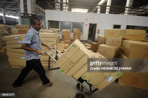 Bangladeshi porter moves cartons of goods in a warehouse at Hazrat Shahjalal International Airport in Dhaka on April 21, 2010. The European aerial...