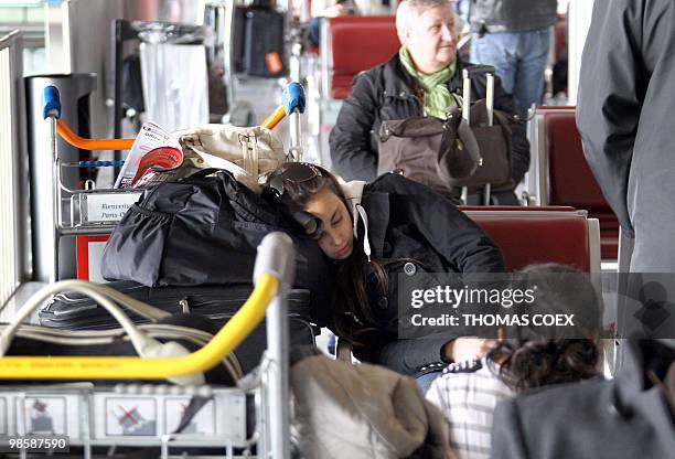 Passenger sleeps on a chair at the Roissy Charles de Gaulle Airport outside Paris, on April 16, 2010. French aviation authorities ordered airports in...