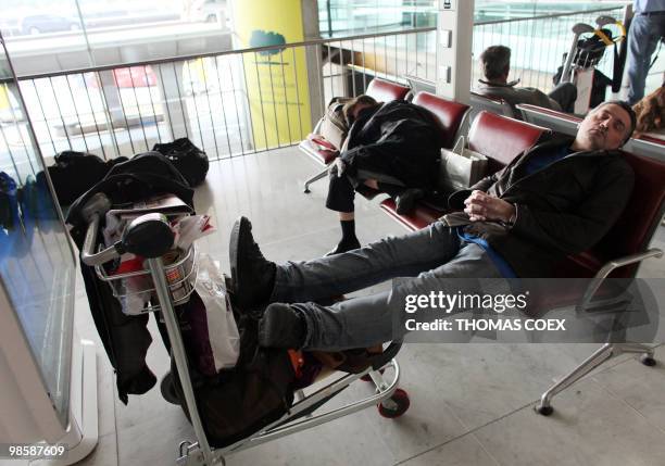 People sleep on chairs inside the Roissy Charles de Gaulle Airport outside Paris, on April 16, 2010. French aviation authorities ordered airports in...