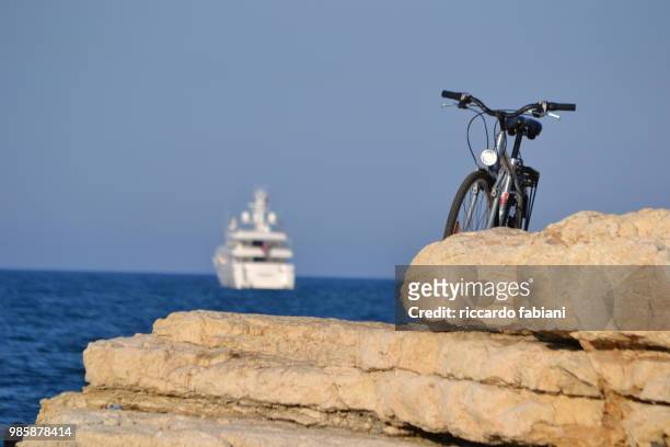 bicicletta e nave su scogli mare italia - bicicletta stock-fotos und bilder