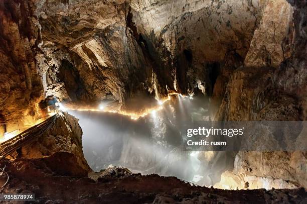 ondergrondse canyon in een donkere grot - grot stockfoto's en -beelden