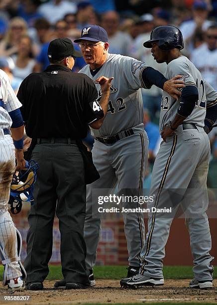 Manager Ken Macha of the Milwaukee Brewers, wearing a number 42 jersey in honor of Jackie Robinson, holds back player Alcides Escobar as he argues...