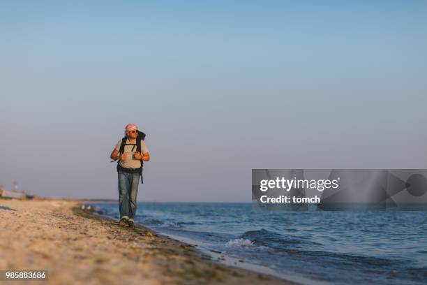 caminhando à beira-mar em um dia ensolarado - língua de areia - fotografias e filmes do acervo