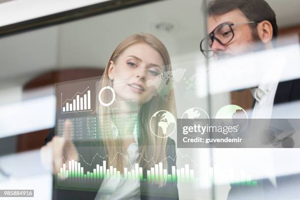 busines couple discussing business profit on a modern interface - big data infographic stock pictures, royalty-free photos & images