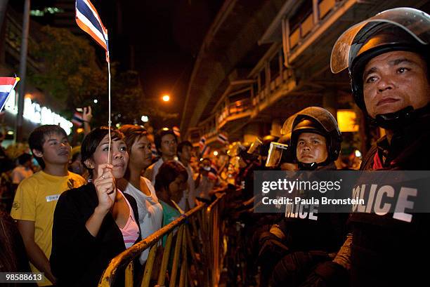 Thai riot police stand guard as government supporters and protesters chant slogans at each other on April 21, 2010 in Bangkok, Thailand. Tension...