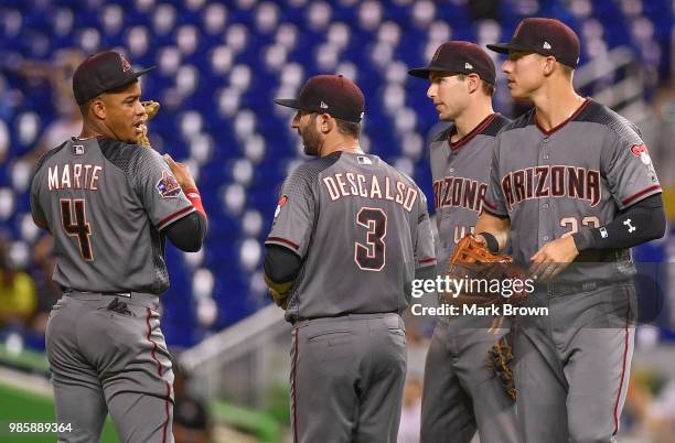 Ketel Marte, Daniel Descalso, Paul Goldschmidt, and Jake Lamb of the Arizona Diamondbacks meet on the infield during a pitching change during the...