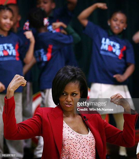 First lady Michelle Obama flexes her muscles as she exercises with schoolchildren at the River Terrace School April 21, 2010 in Washington, DC. Mrs....