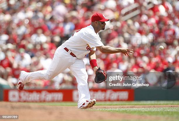 Albert Pujols of the St. Louis Cardinals makes the underhanded toss to first base during the game between the Houston Astros and the St. Louis...