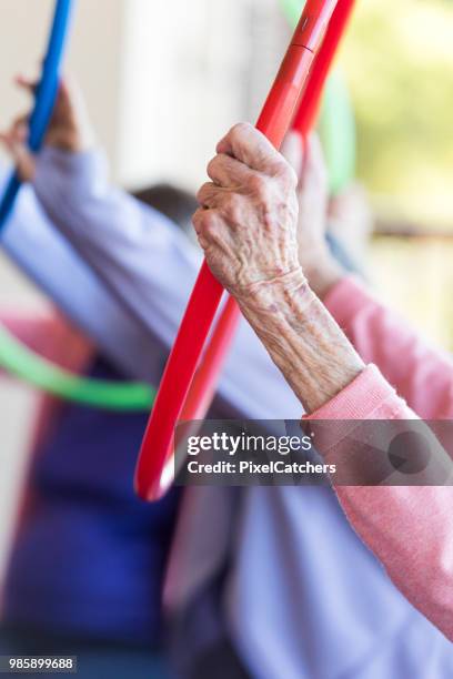 close up of a senior woman holding a plastic hoop above her head - retirement community stock pictures, royalty-free photos & images