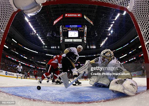 Goaltender Marc-Andre Fleury of the Pittsburgh Penguins attempts to make a save as teammate Sergei Gonchar and Daniel Alfredsson of the Ottawa...