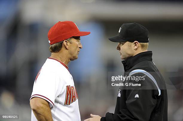 Manger Jim Riggleman of the Washington Nationals talks with first base umpire Mike Estabrook during the game against the Colorado Rockies April 20,...