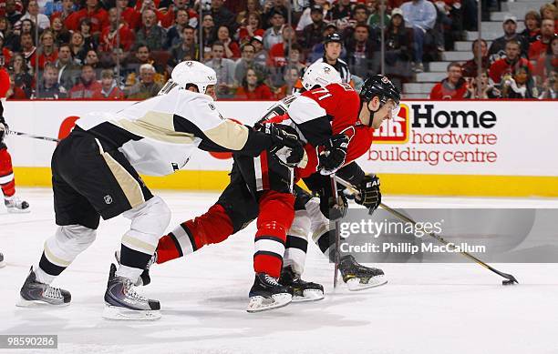 Nick Foligno of the Ottawa Senators skates with the puck while being defended by Mark Eaton and Kris Letang of the Pittsburgh Penguins during Game 3...