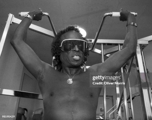 American jazz musician Miles Davis lifts weights, still in his sunglasses, in the health club atop the UN Plaza Hotel, New York, New York, mid 1980s.