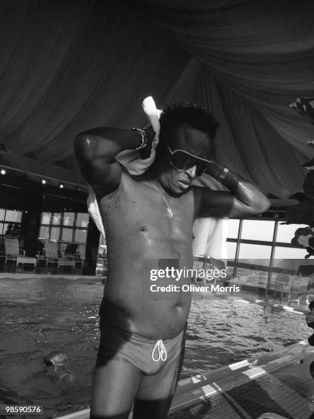 American jazz musician Miles Davis , still in his sunglasses, dries his hair on the deck of the swimming pool at the health club atop the UN Plaza...