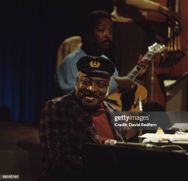 American jazz pianist and composer Count Basie appears on stage, with guitarist Freddie Green behind, during recording of the BBC television series...