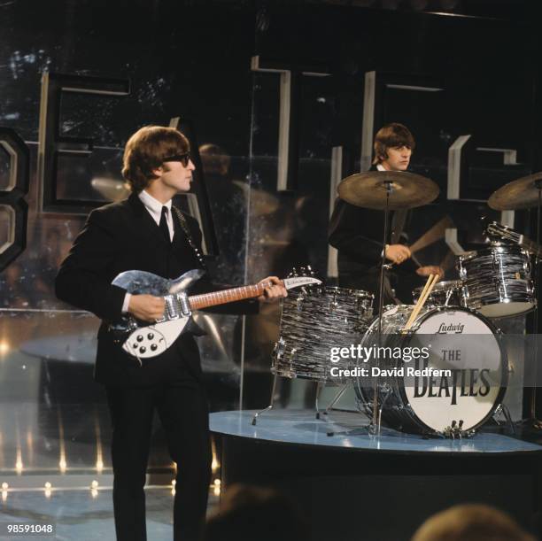 From left, John Lennon and Ringo Starr of English rock and pop group The Beatles perform together on stage for the ABC Television music television...